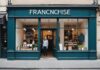 Franchise en France : le secteur franchit un nouveau cap malgré la baisse du nombre de réseaux Commerçant accueillant des clients devant une devanture de franchise moderne