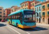 Bus Simulator 27 : le nouveau simulateur de bus d’astragon débarque avec 45 véhicules Bus de transport en commun circulant dans une ville côtière ensoleillée, illustration jeu vidéo