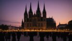 Procession religieuse aux flambeaux au crépuscule devant une basilique
