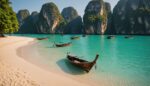 Plage tropicale en Thaïlande avec bateaux longue-queue et falaises calcaires au coucher du soleil